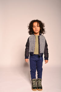 boy wearing blue and white patchwork taffeta and wool bomber jacket