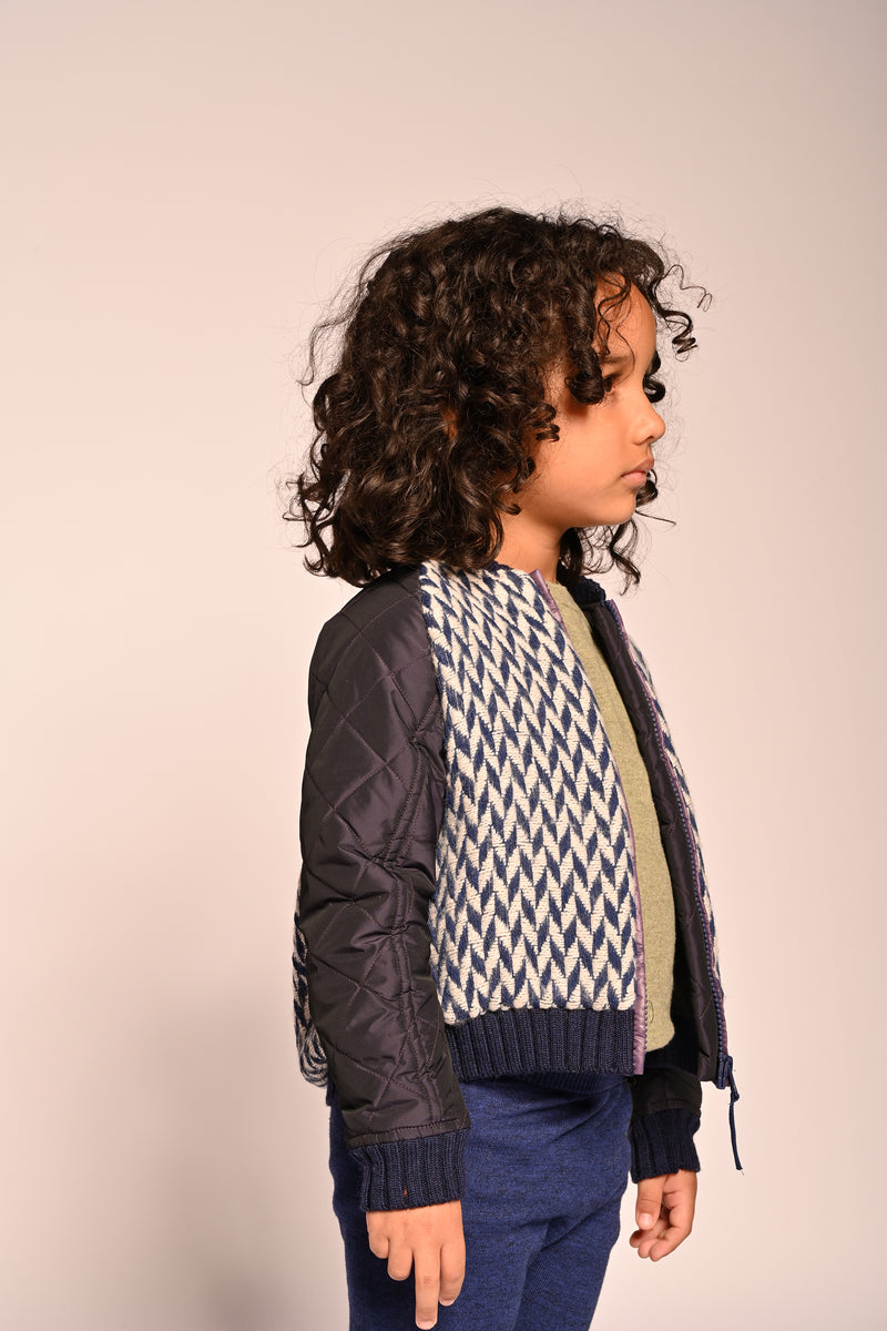 boy wearing blue and white patchwork taffeta and wool bomber jacket