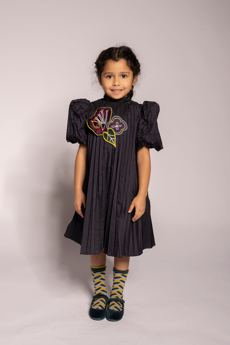 girl wearing dark purple pleated taffeta dress