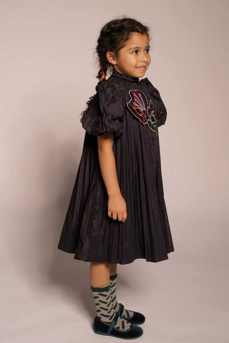 girl wearing dark purple pleated taffeta dress