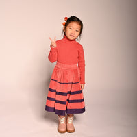 girl wearing red cotton corduroy skirt with purple stripes