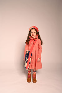 girl wearing red long sleeve cotton dress with blue and white faux fur tote bag with red strap by TiA CiBANi