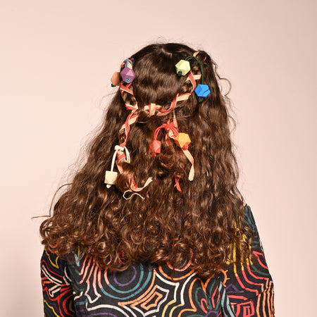 girl wearing set of 4 multicolored hair tie elastics with wooden beads on the end