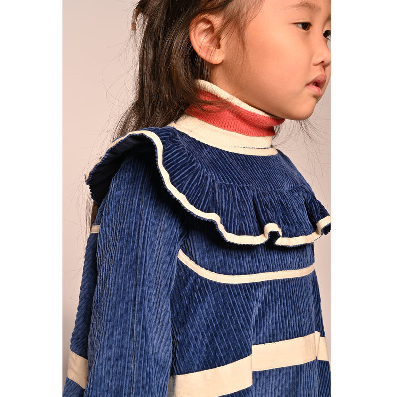 close up of girl wearing blue cotton corduroy dress with sleeves and white stripes
