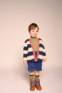 boy wearing cotton knit cardigan with white and blue zig zag stripes