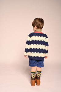 boy wearing cotton knit cardigan with white and blue zig zag stripes