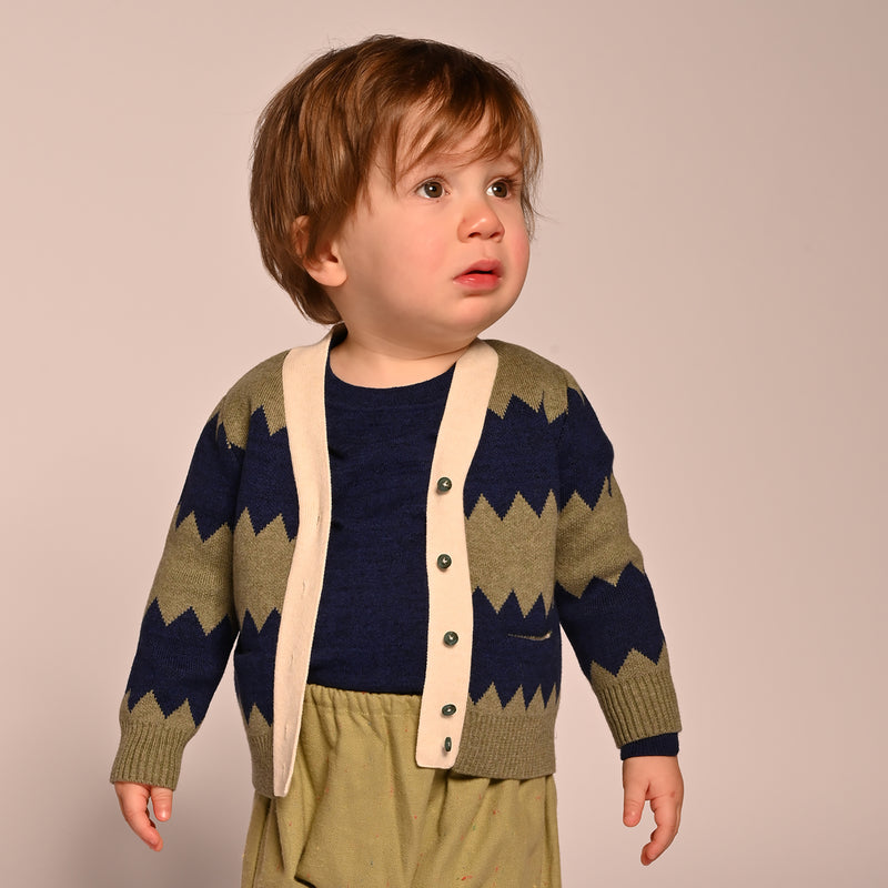 baby boy wearing knitted cotton cardigan with blue and green zig zag stripes