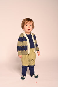 baby boy wearing knitted cotton cardigan with blue and green zig zag stripes