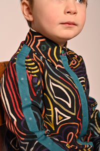 Boy wearing collared snap button down shirt with all over print in fine corduroy