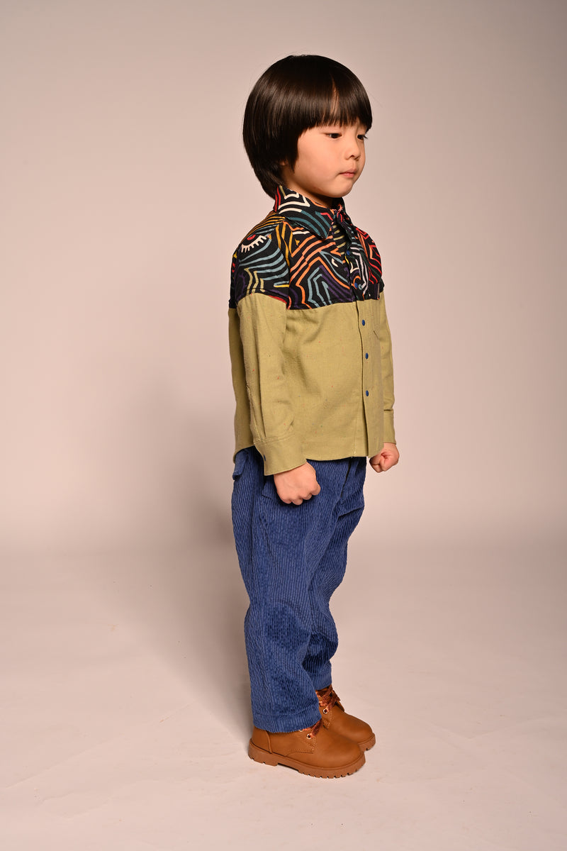 boy wearing green button up collared shirt with printed fine corduroy on the shoulders