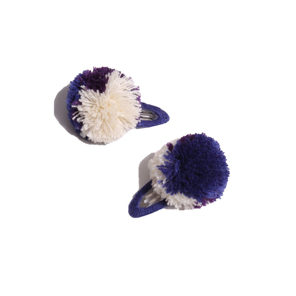 two barrette hair clips with a blue and white pom pom
