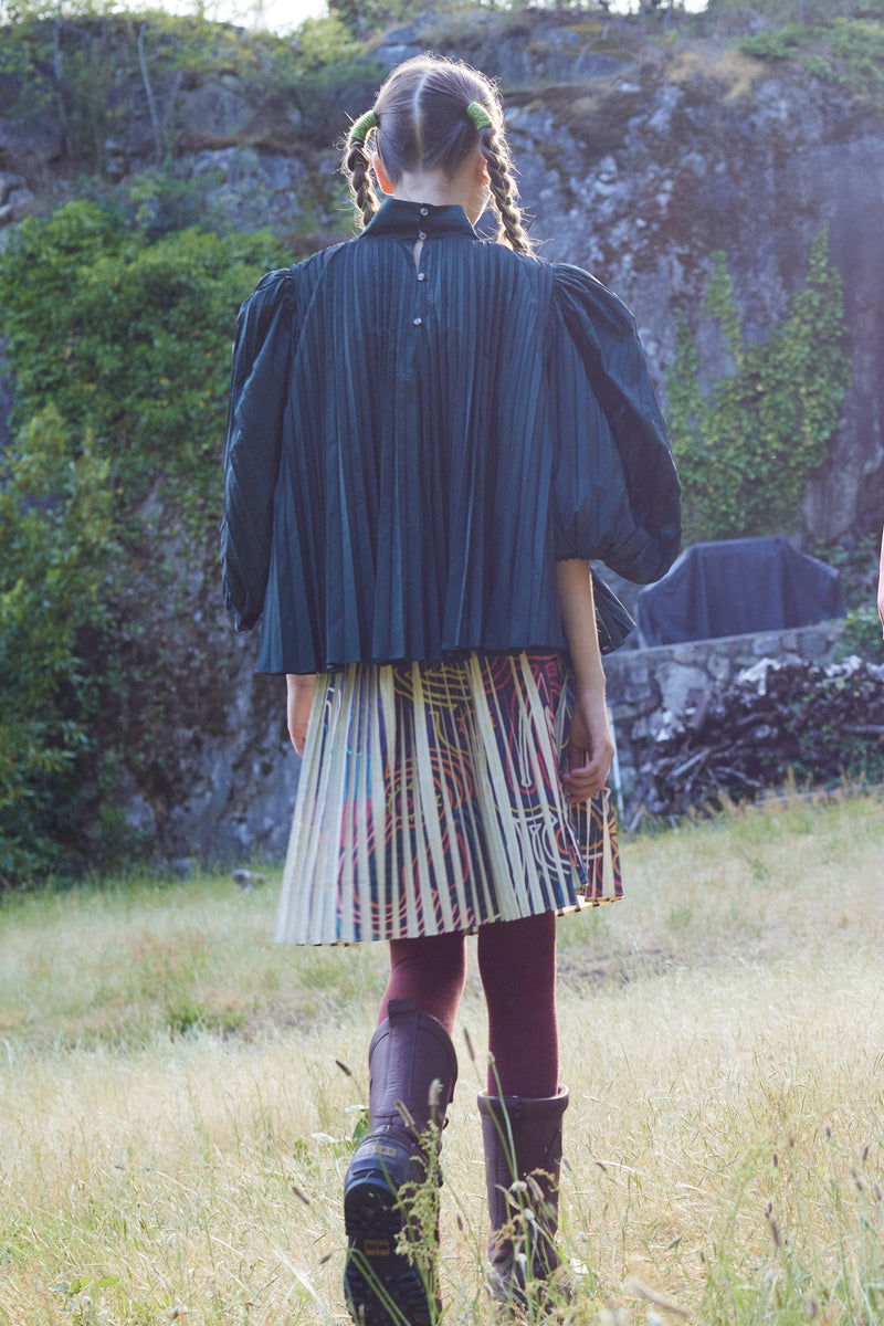 girl wearing pleated taffeta skirt with all over print